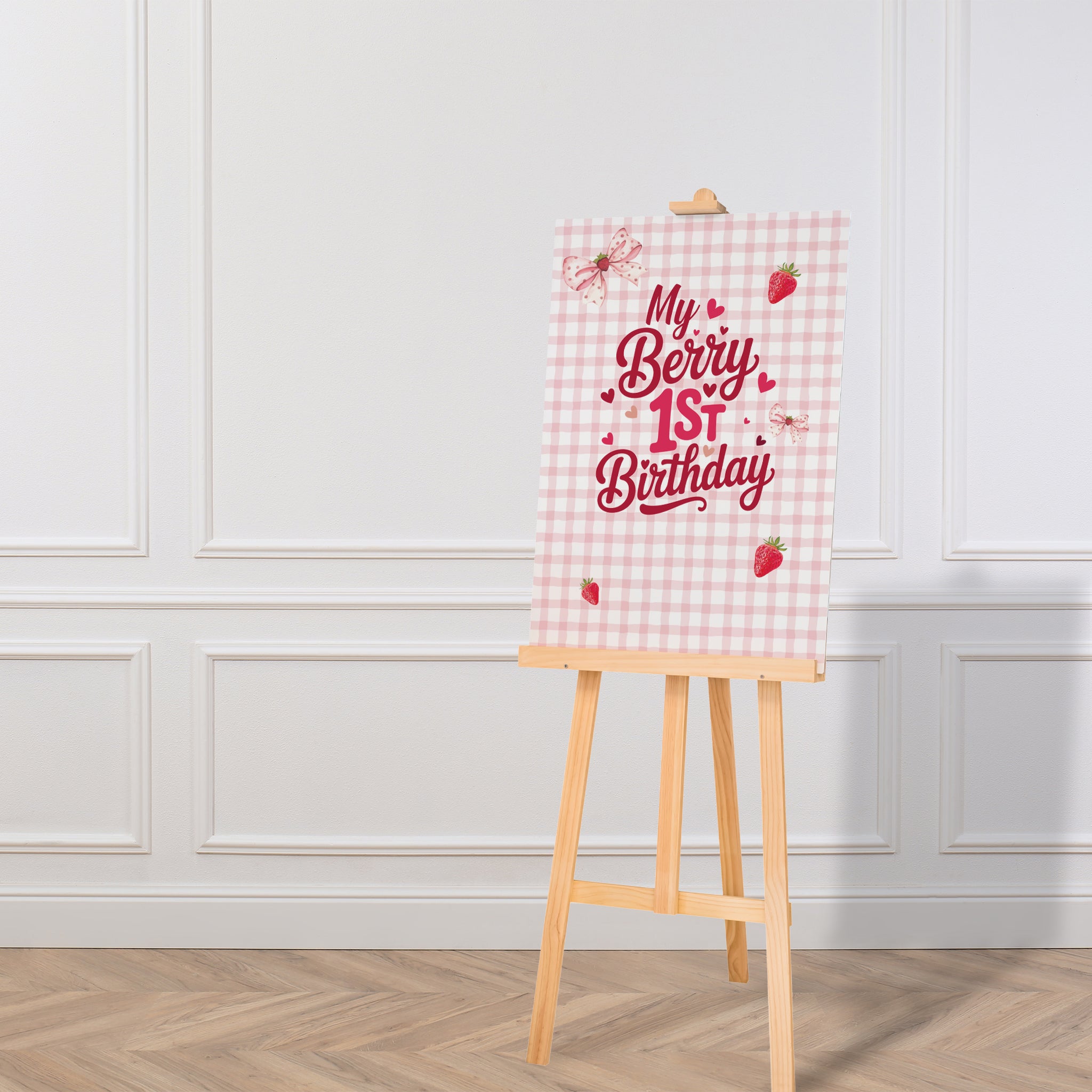 Decorative sign with 'My Berry 1st Birthday' text on a checkered background, displayed on an easel against a white wall.