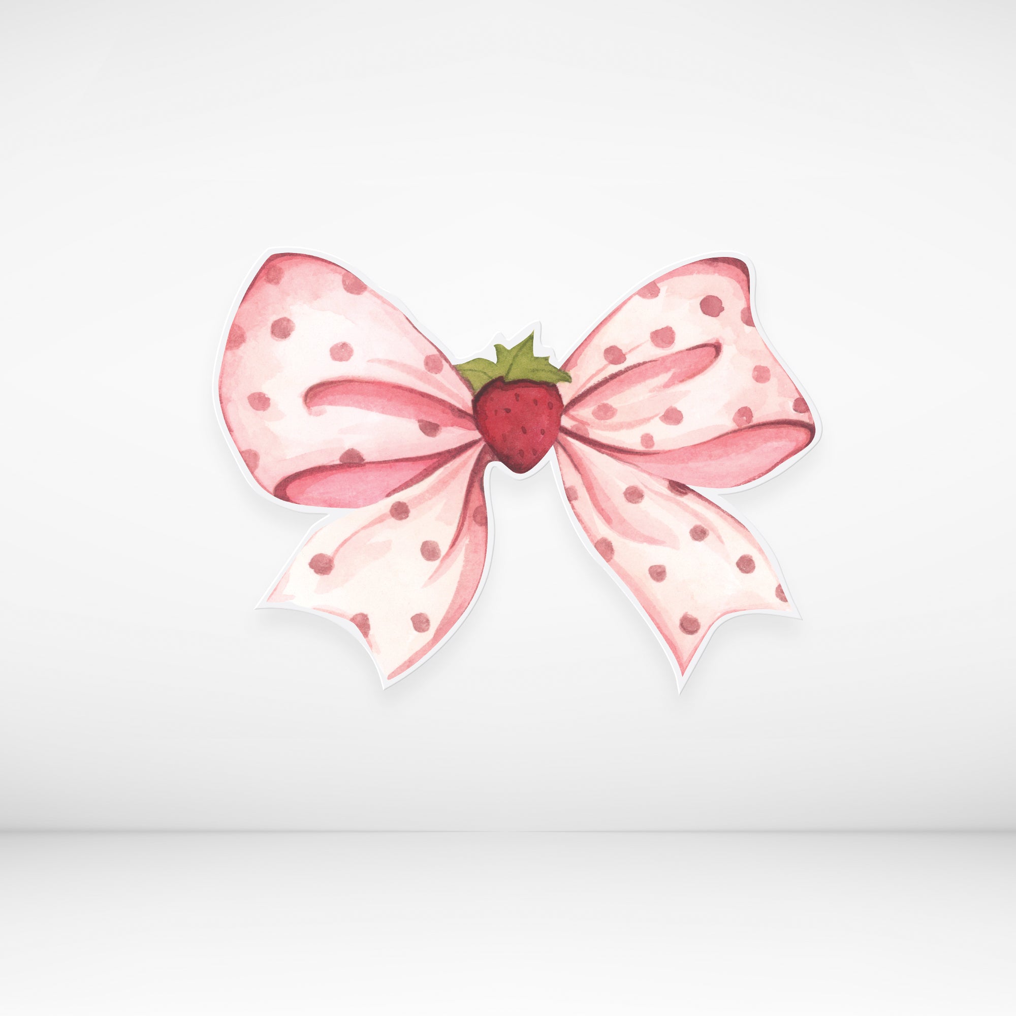 Pink polka dot bow cardboard cutout with a strawberry in the center on a light gray background