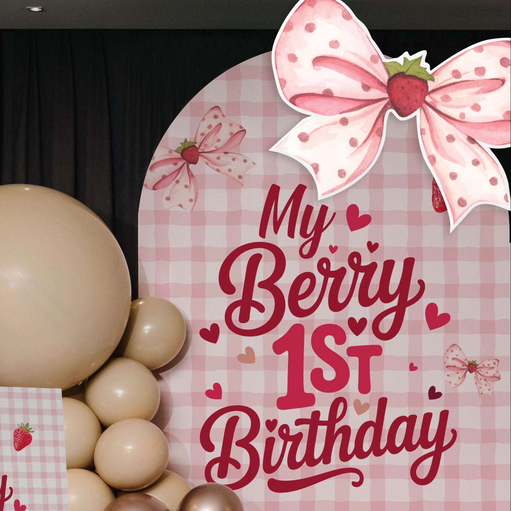 Decorative setup for a child's first birthday with balloons and a sign on a checkered background.